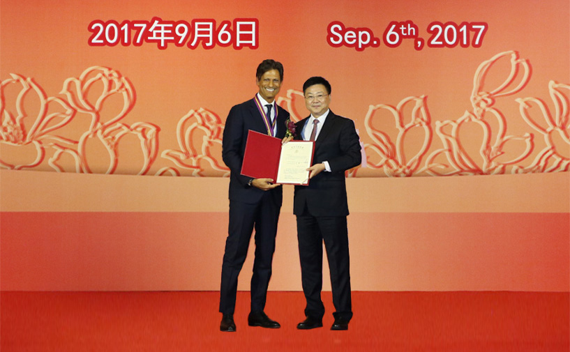 上海市政府外办主任张小松向郭伟诚授予“白玉兰纪念奖”奖牌和证书